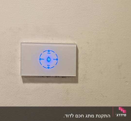 מתג חשמלי עם תאורה כחולה על קיר